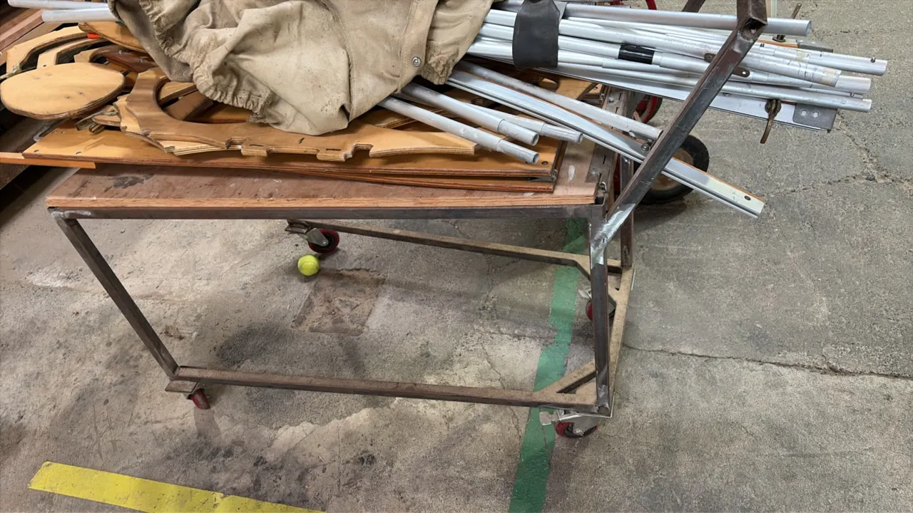 Metal rolling platform cart. Features steel frame construction with a wood top deck. 4'L. Mounted on swivel casters. Contents not included.