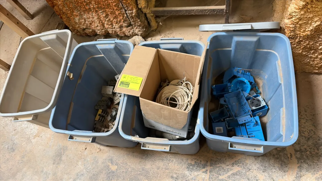 Assortment of electrical parts and supplies. Includes plastic junction and outlet boxes, coiled wire, electrical components, and (3) blue plastic stor