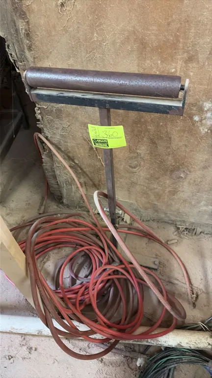 Metal roller material support stand. Includes coiled red pneumatic air hose.