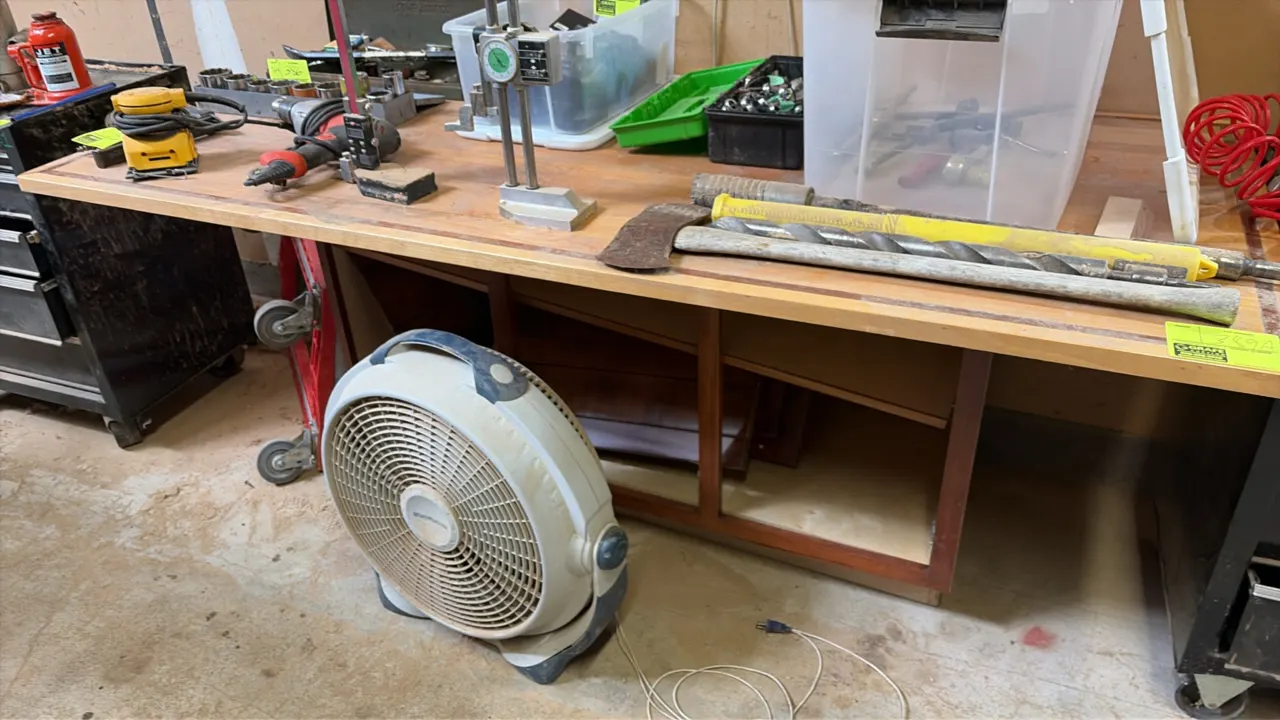 Wood top work table. Features a wood work surface and lower open storage compartment. Includes an electric pivoting floor fan. 74" x 36". Table conten