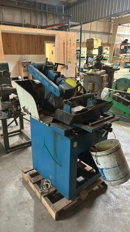 Nielsen Tool Co. circular cold saw. Features integrated splash guard enclosure, coolant distribution lines, and enclosed steel cabinet base. Electrica
