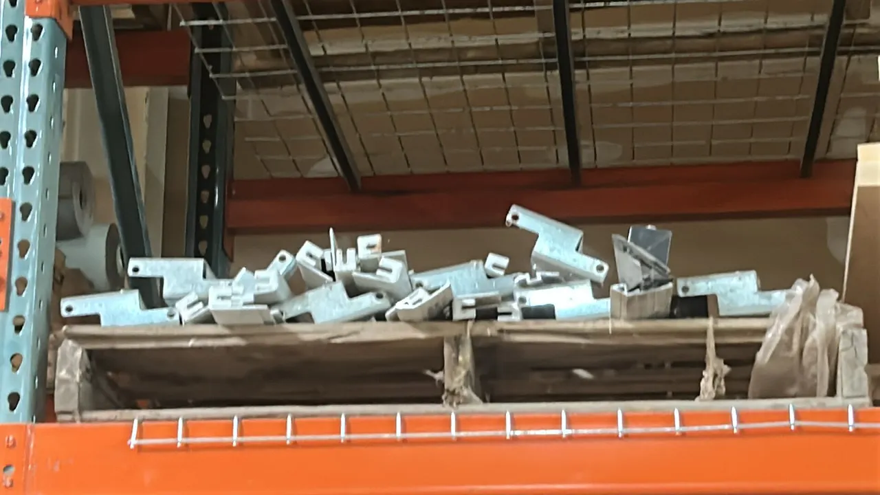 Assortment of metal mounting brackets. Features galvanized steel construction. Pallet racking and background warehouse items not included.