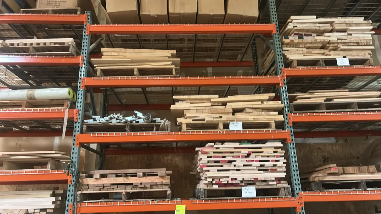 Assorted glued panels and lumber. Includes sugar pine, maple, and mixed hardwood panels in various sizes. Stored on wooden pallets. Pallet racking not