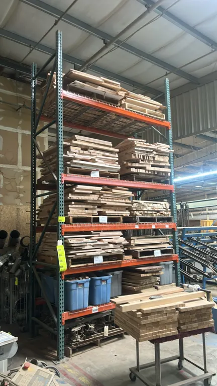 8'L of teardrop pallet racking. Features green metal uprights, 4" orange crossbars, and wire mesh decking. Dimensions: 8'L x 3'8"W x 13'H. Contents no