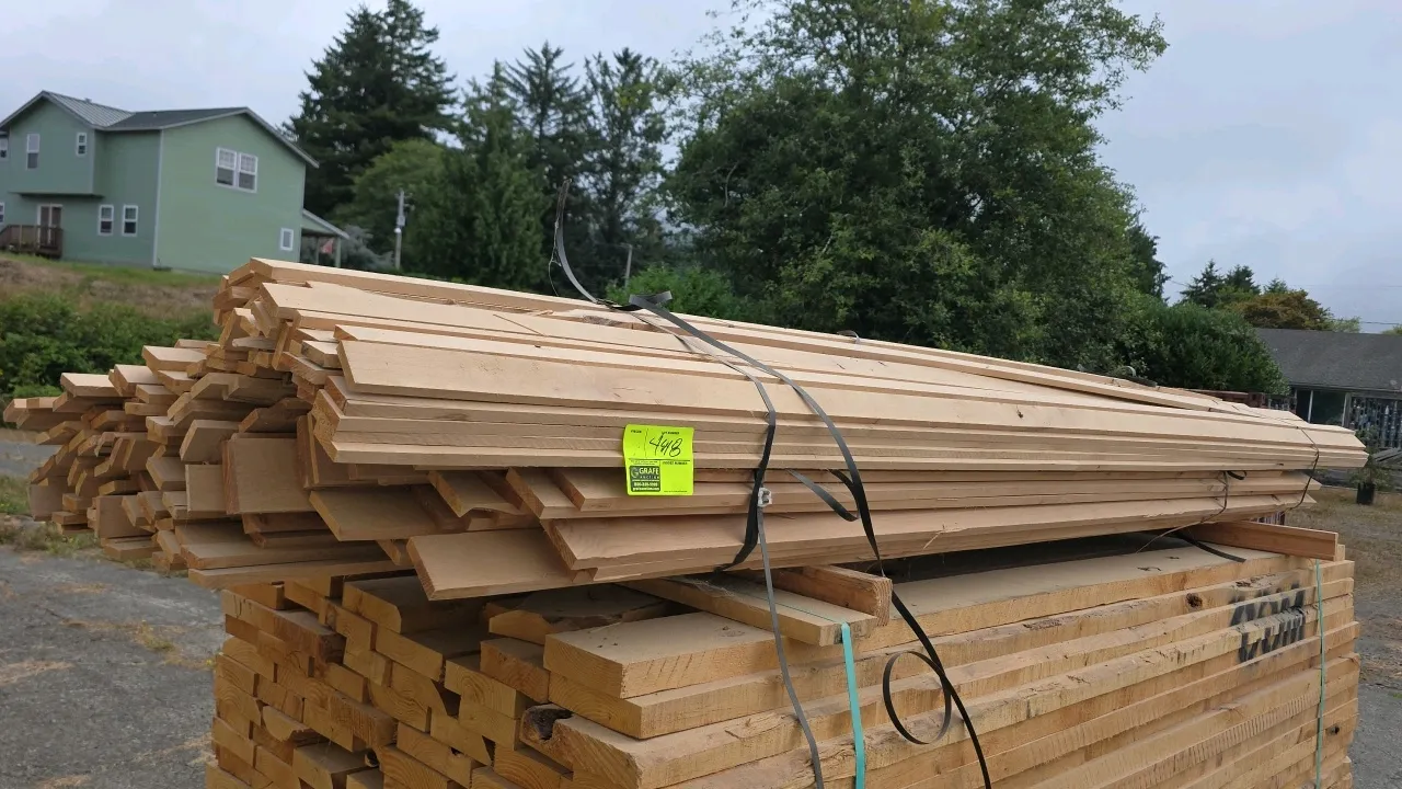 Assorted bundle of hardwood lumber. Strapped bundle of various width boards. Approx. 10'L x 1/2"T. Note: Lower stack of lumber beneath tagged bundle i