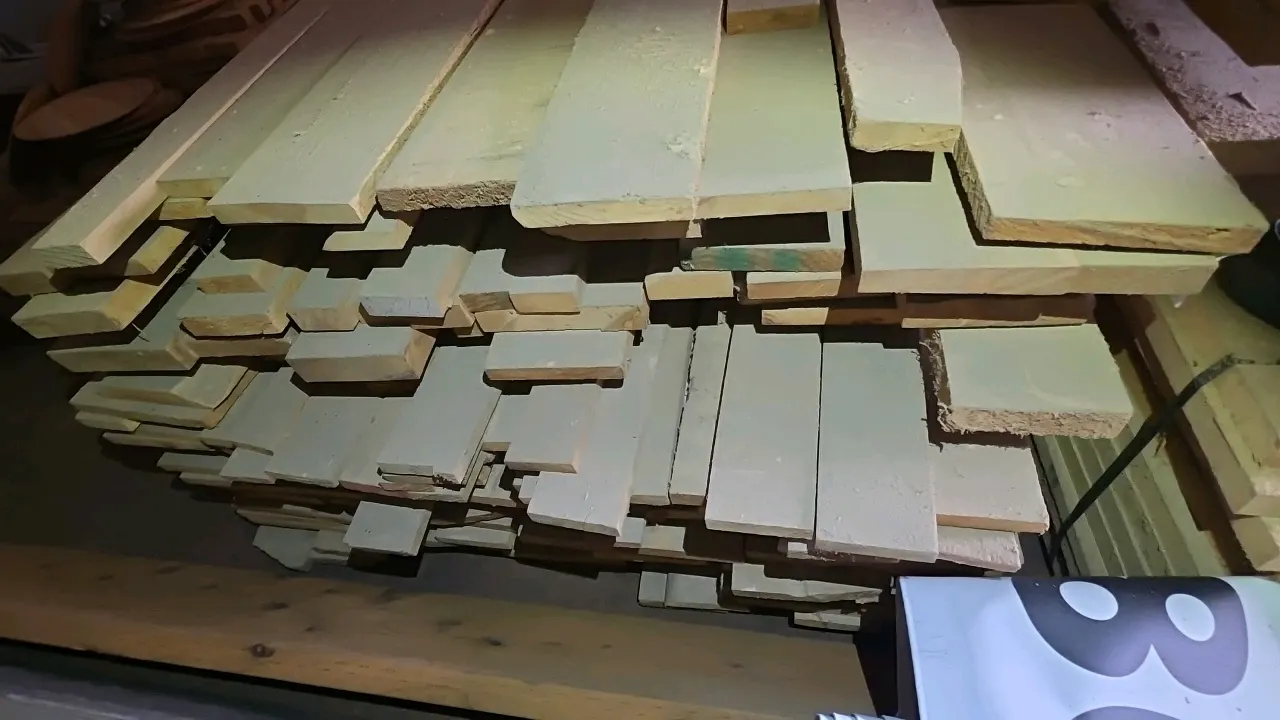 Bundle of assorted hardwood lumber. Features rough-sawn boards in assorted widths and thicknesses. Approx. 8'L. Banded stack. Surrounding materials an