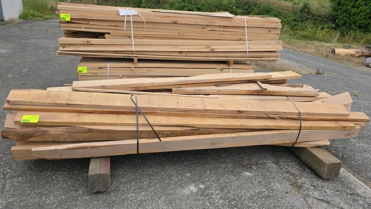 Banded bundle of alder wood lumber. Features rough-cut boards in mixed widths. Approx. 9'6"L x 1-1/2" thick.