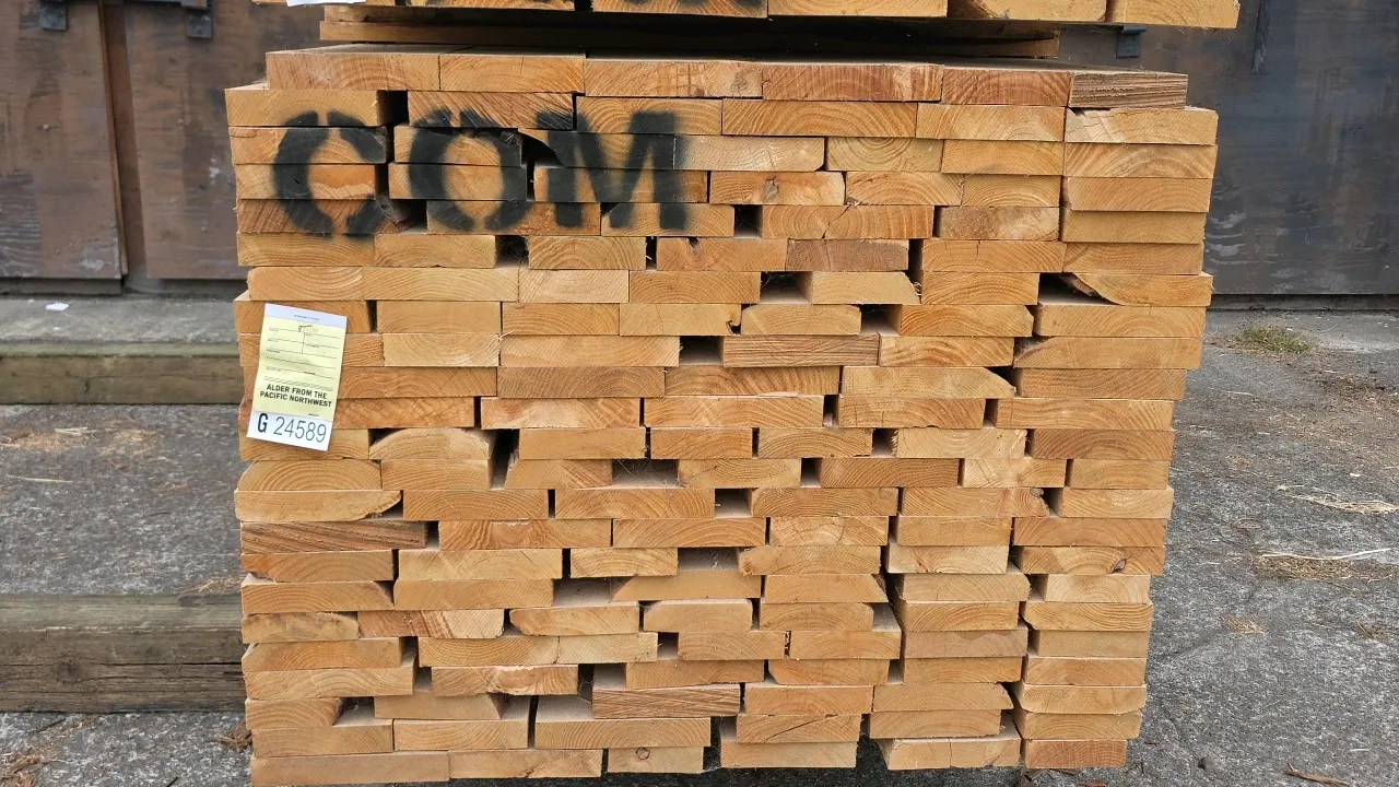 Bundle of Pacific Northwest Alder lumber. Grade: Common (COM). Marked as 1,202 board feet of 6/4 (1-1/2" thick) lumber, approximately 10'L. Tag No. G