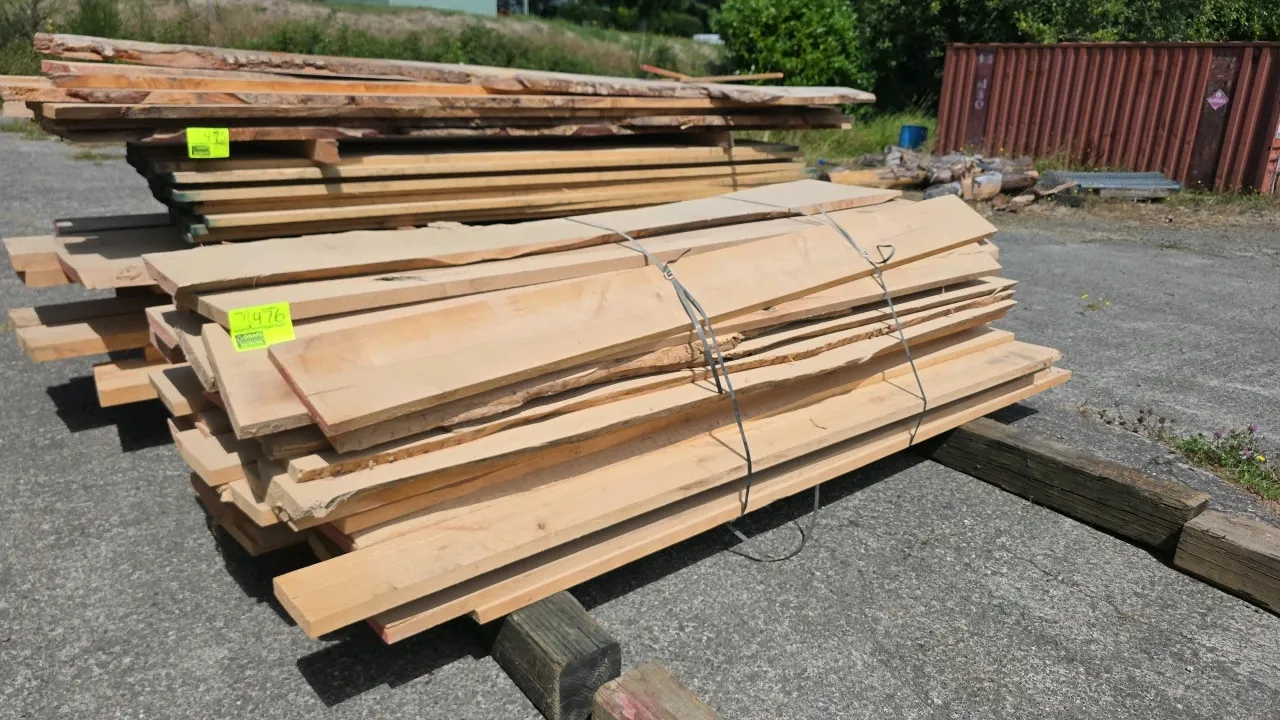 Bundle of assorted hardwood lumber. Features rough sawn and live-edge boards. Approx. 8'L x 1-1/4" to 1-1/2" thick. Bound with metal banding.