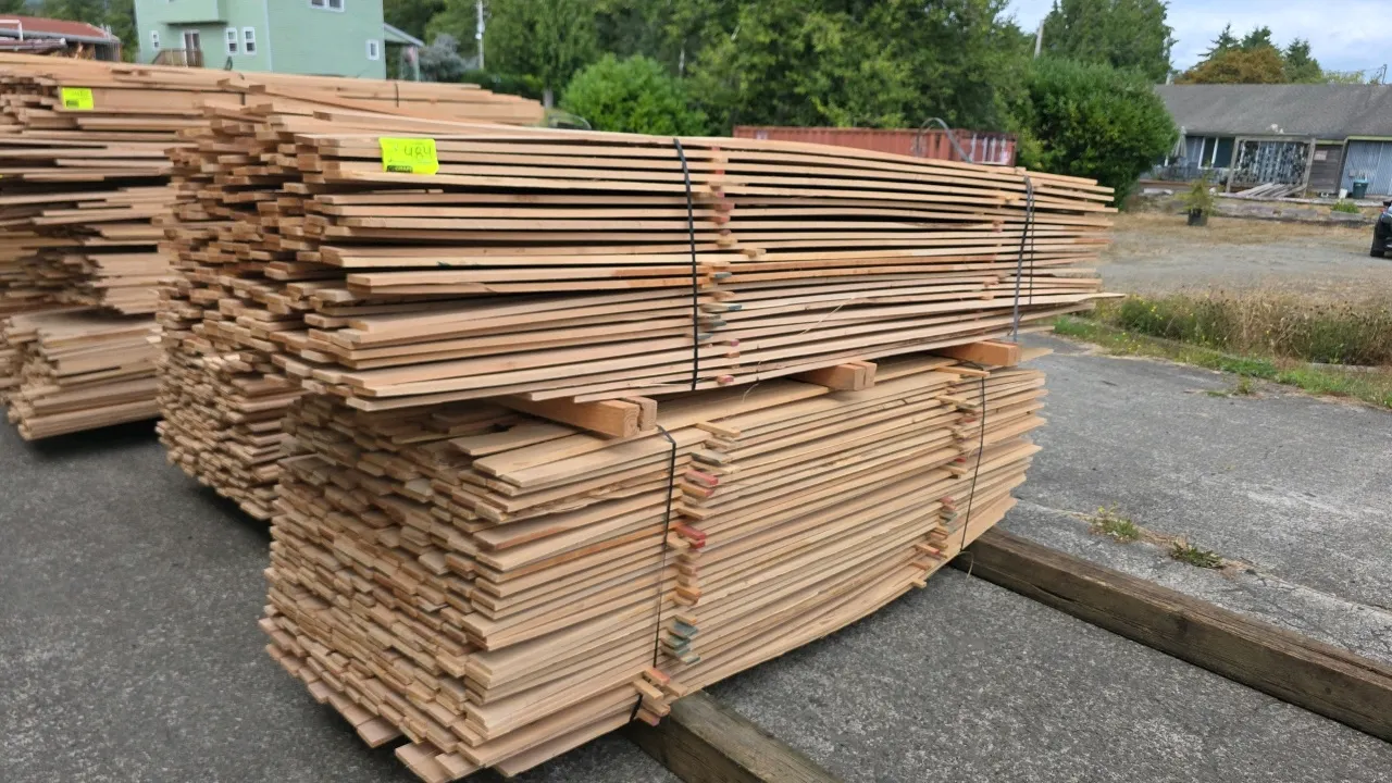 Bundles of alder hardwood lumber. Features stickered layers with banded strapping. Approx. 8' to 10'L x 1/2" thick. Background equipment not included.