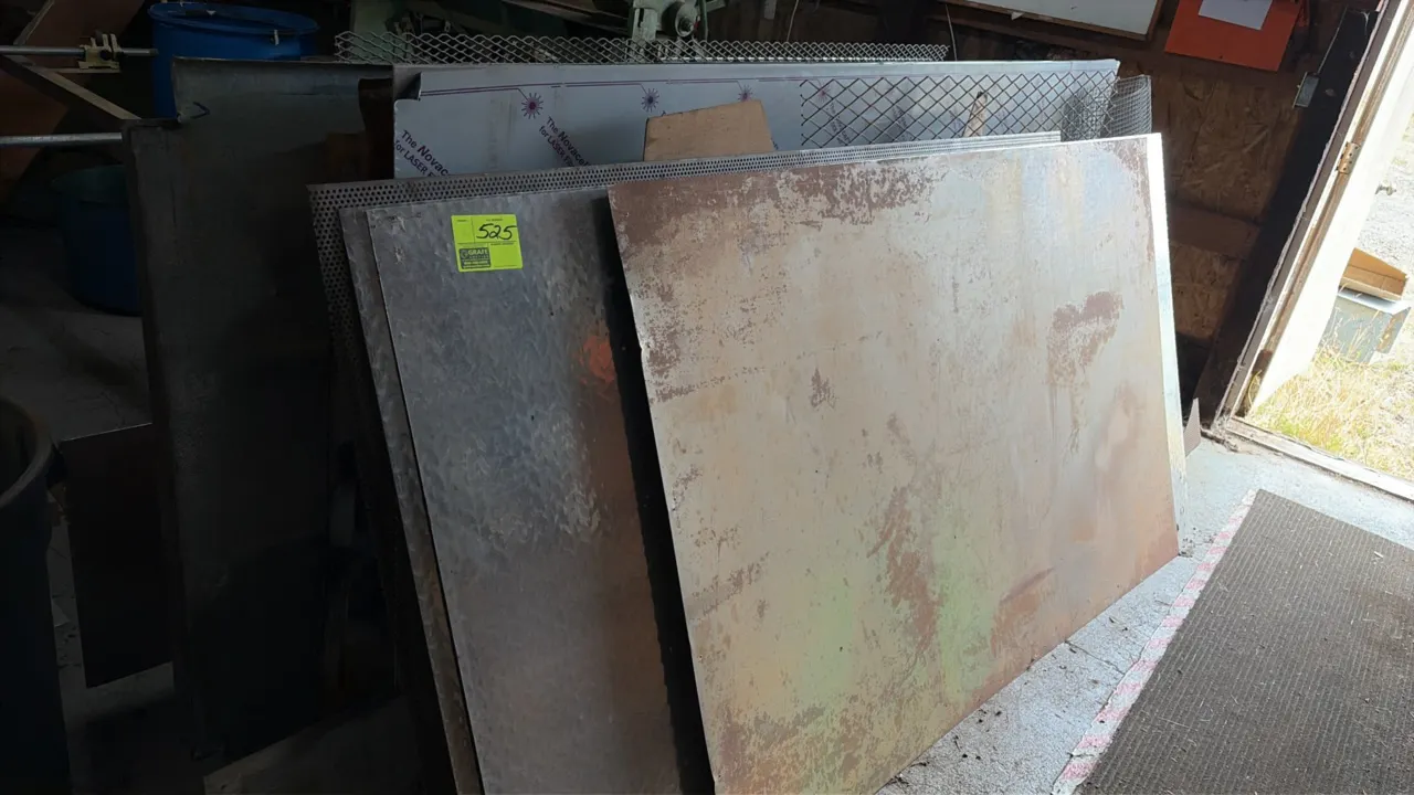 Assorted sheet metal stock with storage rack. Includes steel sheets, diamond plate, perforated metal, and rolled wire mesh.