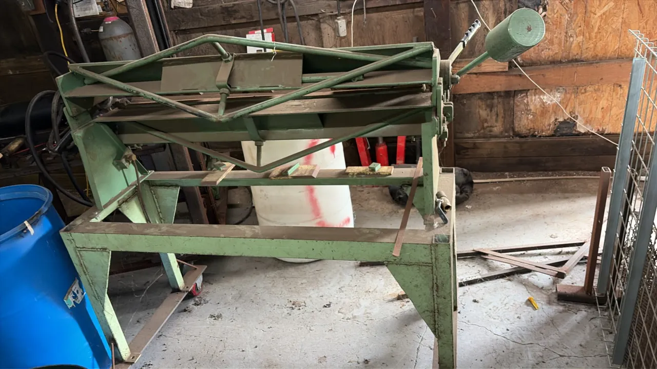 Box and pan hand brake. Features segmented fingers for sheet metal angle and box forming, counterweight balance, and manual operating levers. Mounted