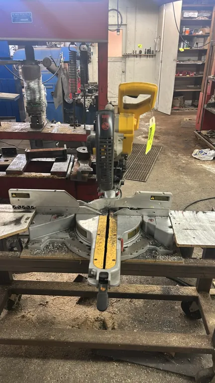 DeWalt 12" double-bevel sliding compound miter saw. Features sliding dual rails, adjustable miter base, tall fence, and blade guard. Table and cart no