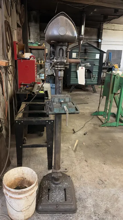 Floor model drill press. Features cast iron construction, adjustable height work table with mounted drill press vise, keyed chuck with drill bit, top