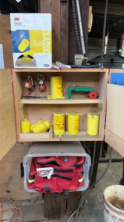 Lockout/tagout station and emergency medical kit. Includes a wooden wall-mount cabinet with assorted lockout devices, safety padlocks, plug lockouts,