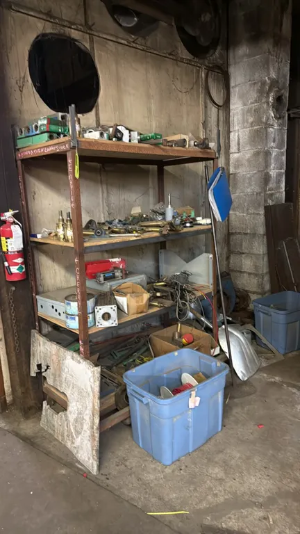 Metal storage rack with assorted industrial parts. Includes 4-tier steel shelving rack, pneumatic cylinders, pillow block bearings, linear guide block