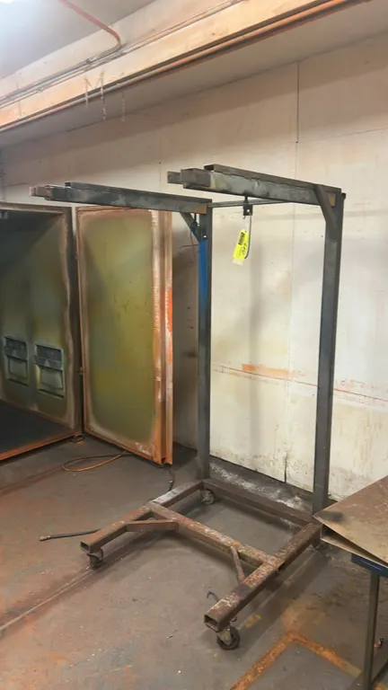Metal portable hanging parts drying rack. Features welded steel tubular construction with dual overhead cantilevered hanging rails. Mounted on casters