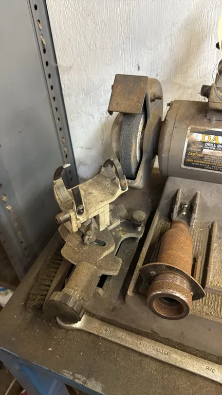 Darex drill sharpener. Features dual grinding wheels and drill sharpening fixtures. Electrical: 115V, 60 Hz, 4.2A, 1/3 HP, 3450 RPM. Mounted on a blue