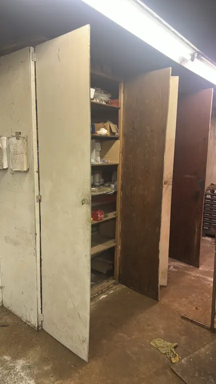 Wooden storage cabinets with assorted contents. Includes cutting tools, machine tooling and bits, vintage industrial machine parts, wooden brush handl