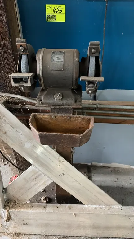 Wards Lakeside electric bench grinder. Features dual grinding wheels, wheel guards, dual tool rests, and an integrated lower quench tray. Mounted on a