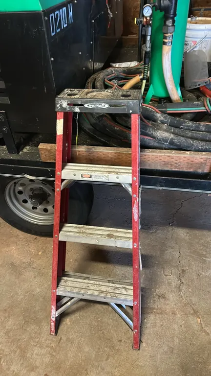 Werner 4' fiberglass stepladder. Features red fiberglass non-conductive side rails, aluminum steps, molded top with tool slots, and external pinch-res