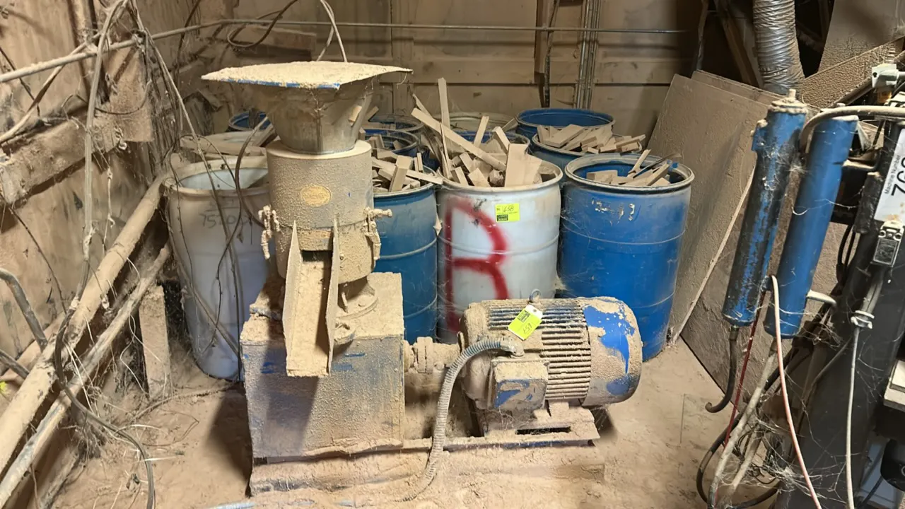 Industrial electric motor-driven grinder. Features top funnel hopper, discharge chute, and direct-coupled drive motor. Mounted on a steel base skid. D