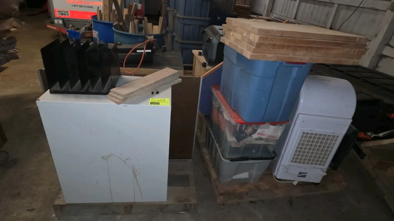 Assorted office and household goods on pallets. Includes a 2-drawer metal file cabinet, 3-drawer cabinet, wooden stand, plastic storage totes, compute