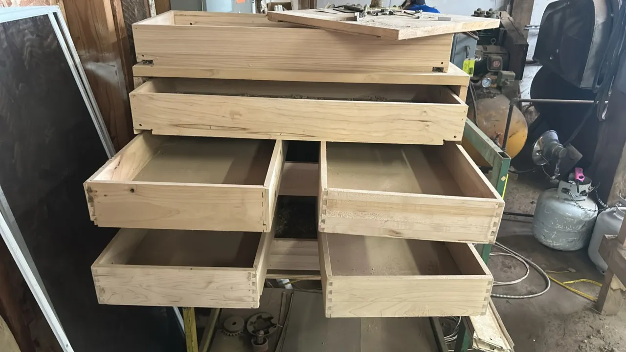 Custom hardwood cabinet on a metal cart. Features unfinished hardwood construction with multiple pull-out drawers and top surface. 44" cart frame with