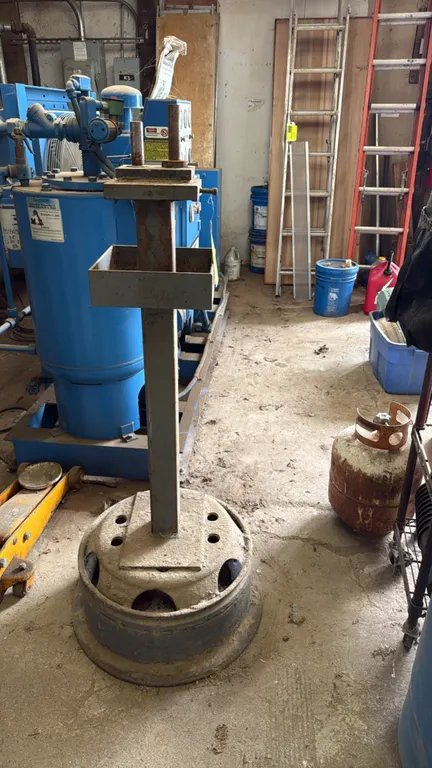 Metal tool stand. Features square tubular steel upright, integrated square parts tray, and upper mounting plate with dual steel pins. 50"H. Mounted on