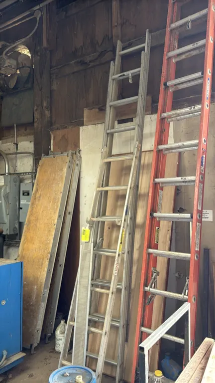 Aluminum extension ladder. Features 2-section extendable construction with rung locks. Dimensions: 20'L. Orange ladder, planks, and surrounding items