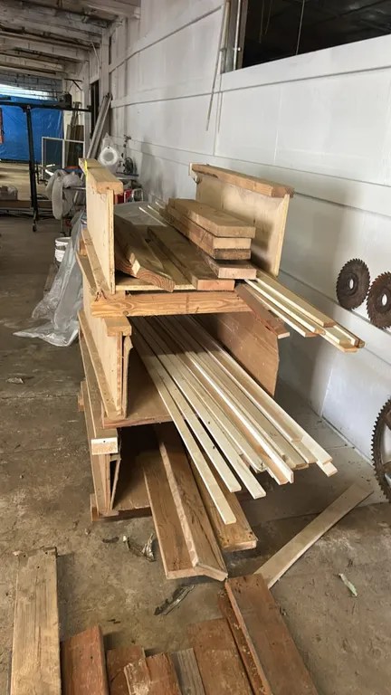 Assorted hardwood lumber lot. Includes various dimensions and lengths of boards, trim strips, and cutoffs. Housed in three stackable wooden storage cr