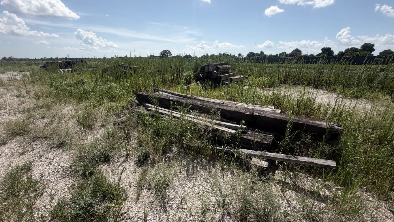 FOUR PILES OF RAILROAD TIES AND LUMBER