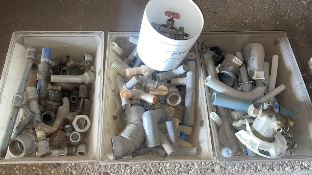 Assortment of plumbing fittings. valves, and
