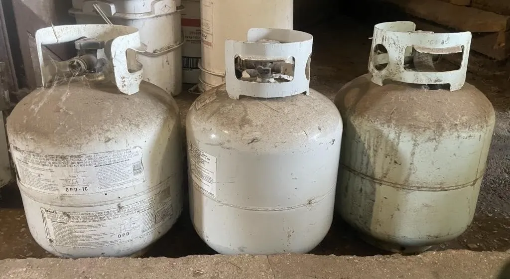 Three 20 lb. expired propane tanks.