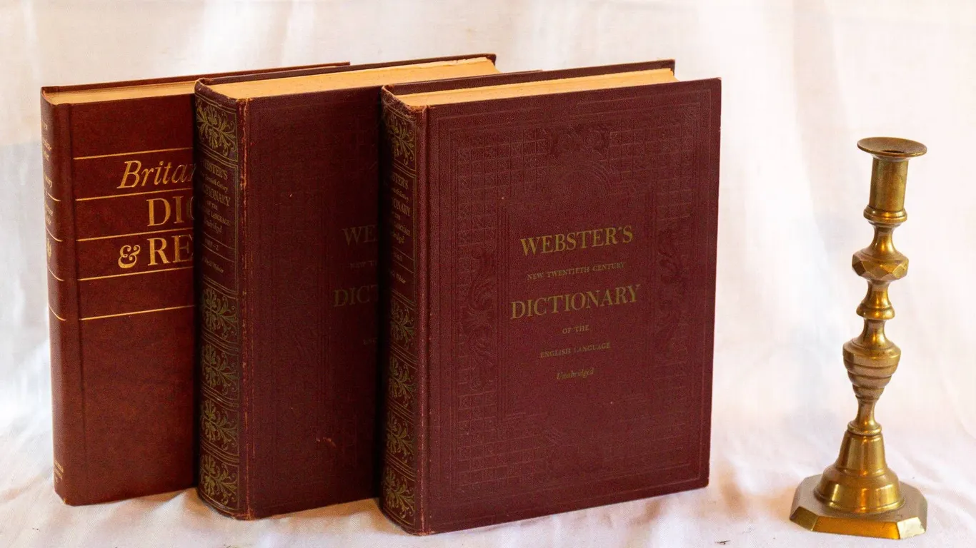 WEBSTER'S DICTIONARY AND BRASS CANDLESTICK.