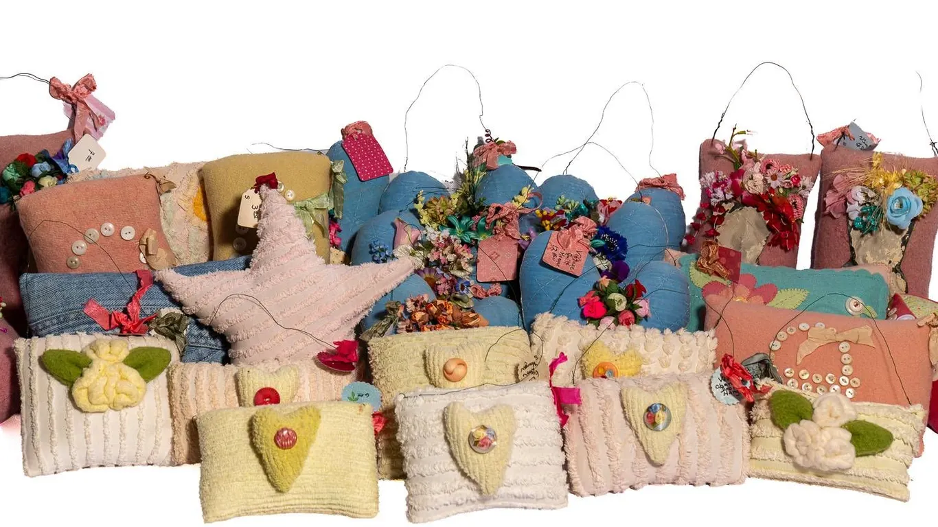 HANDMADE PILLOWS WITH ANTIQUE BUTTONS AND DECORATIVE FLORAL ACCENTS.