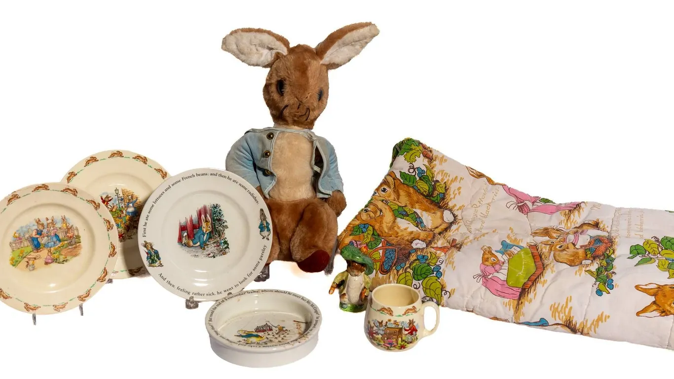 PETER RABBIT ITEMS INCLUDING STUFFED ANIMAL, BLANKET, AND DISHES.