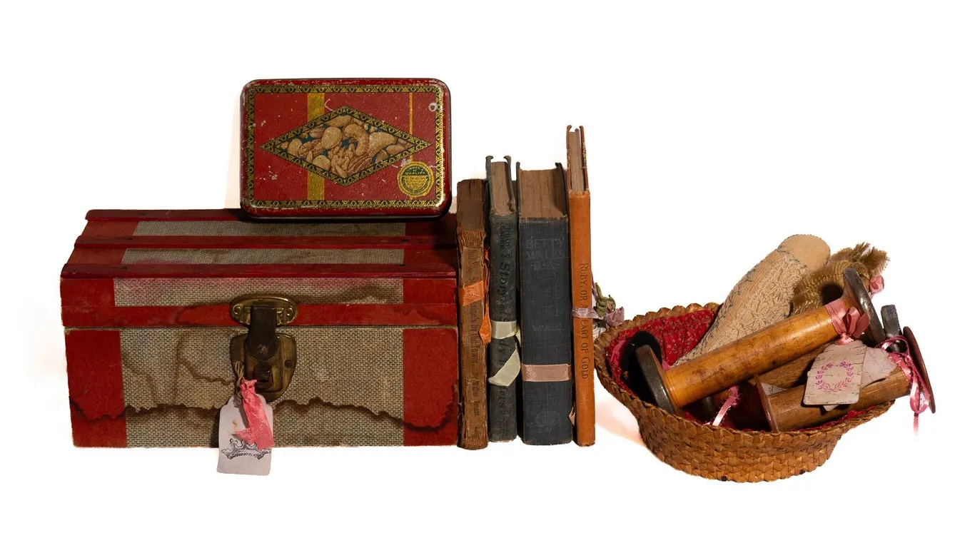 DECORATIVE BOUND BOOKS, SEWING SPOOLS, MINI TRUNK, AND NUT TIN.