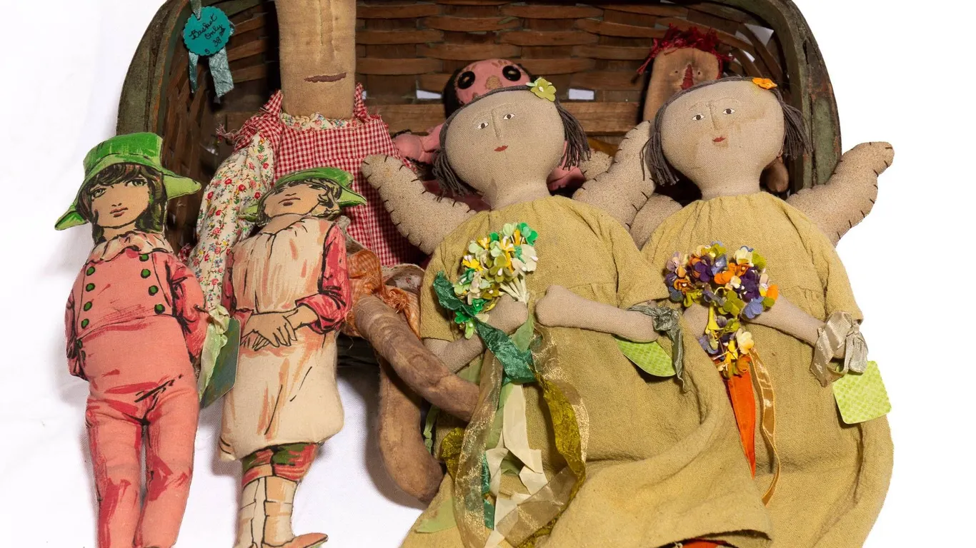 GREEN WOVEN BASKET WITH PRIMITIVE AND FOLK ART DOLLS.