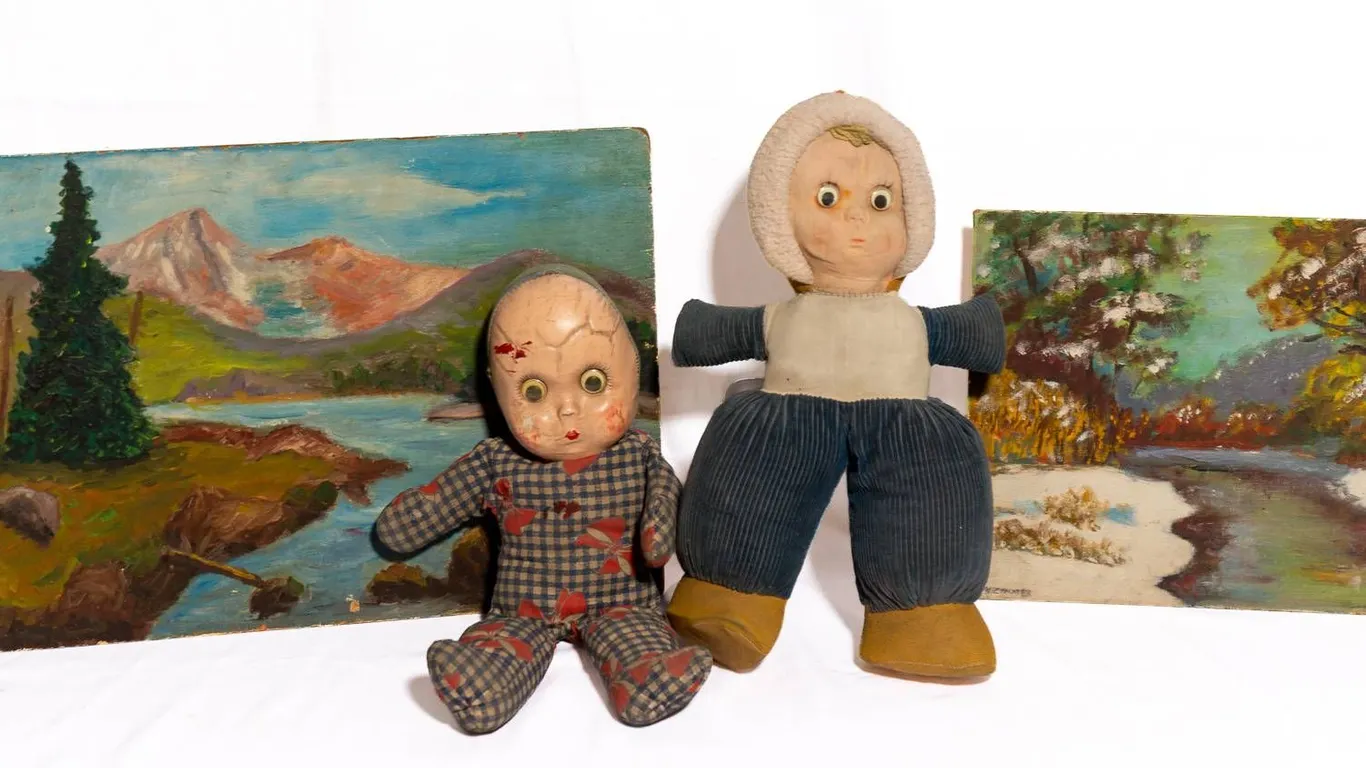 TWO PAINTED CANVAS BOARDS AND TWO VINTAGE DOLLS.