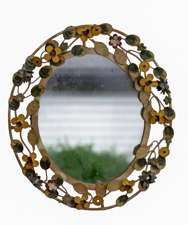 ORNATE FLORAL OVAL MIRROR WITH DECORATIVE FRAME.