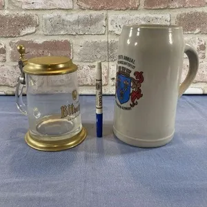 (2 PCS) GERMAN STEINS - 1 CERAMIC, 1 GLASS & BRASS