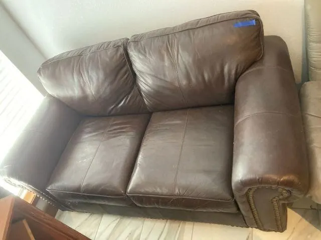 DARK BROWN LOVESEAT WITH NAIL-HEAD TRIM;