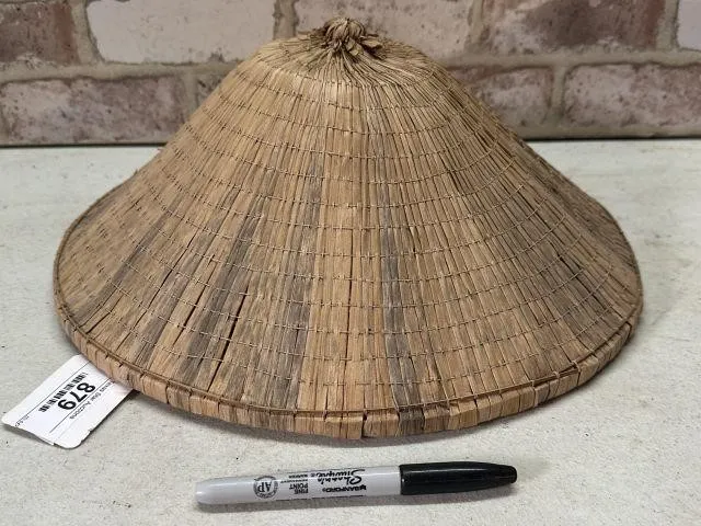 A TRADITIONAL HANDWOVEN STRAW CONICAL HAT