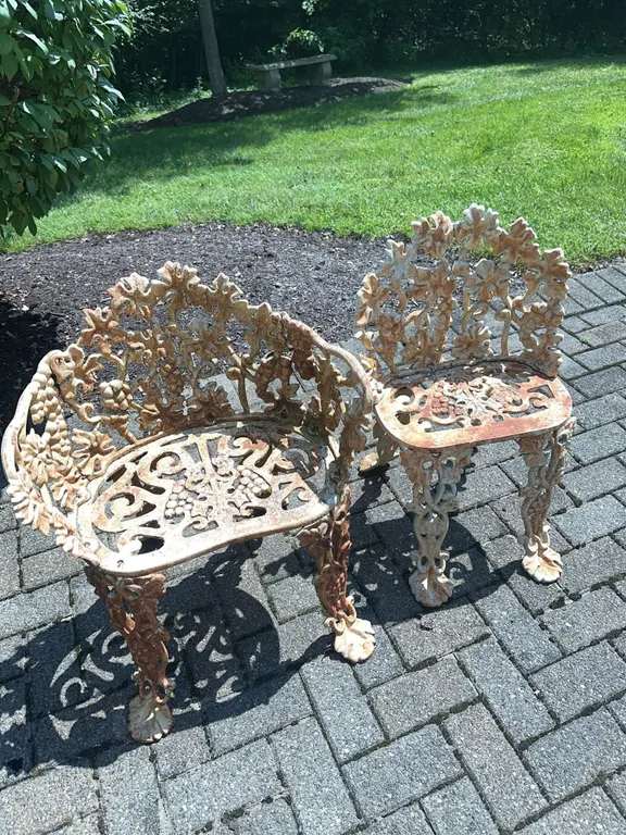 Two cast iron metal chairs