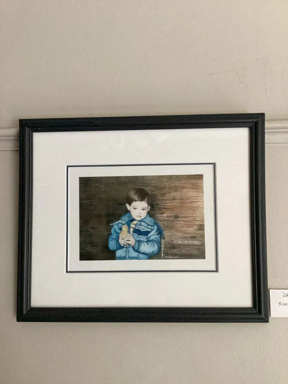 Framed watercolour painting titled 'Oh So Soft' depicting a young child in a blue jacket holding a s