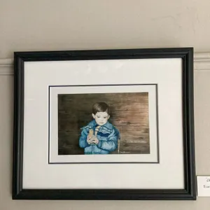 Framed watercolour painting titled 'Oh So Soft' depicting a young child in a blue jacket holding a s