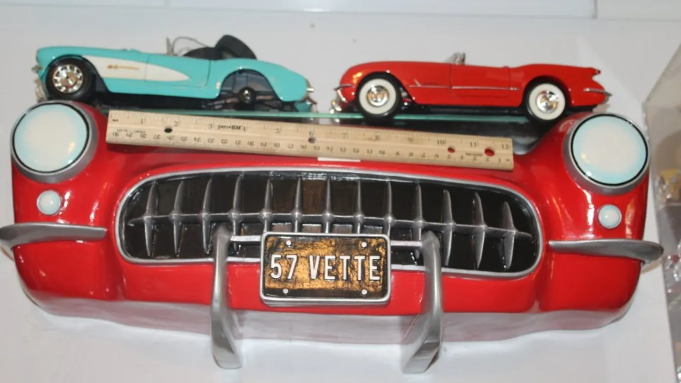 1957 Corvette Display Shelf with Two 1:18 Scale Diecast Including 1957 Corvette with a Loose Windshield and Two Loose Wheels, and a 1954 Corvette by M