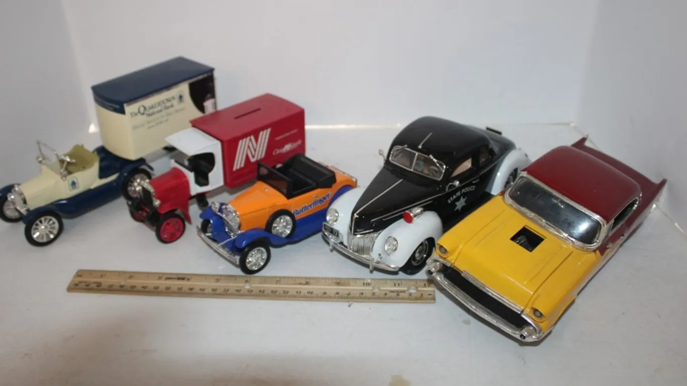 1957 Die Cast Chevy (Missing Wheels), Maisto 1939 Deluxe State Police, Model T with Trailer Butterfinger Bank, and Kenworth Bank (Five Pieces Total)