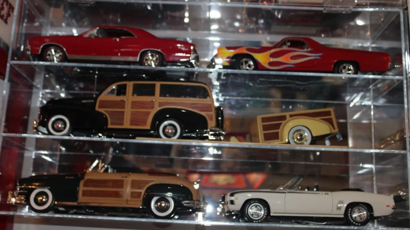Plexiglas Display Case with 5 1:18 Scale Diecast Models and a Pull Behind Trailer, Including a 1969 Chevy Camaro, 1948 Chrysler Town and Country Woody